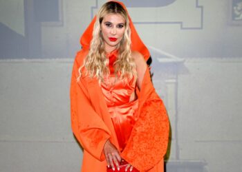 Clizia Incorvaia osa alle sfilate di Milano, look total orange con capospalla e cappuccio: foto